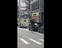 Man ride tall bike carry extra wheels