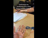 Guy controls his professors arm with wires