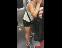 Boa snake wraps around mans shoulders and neck while woman pets it on subway train