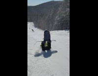Guy sits on snowboard on top of skier 