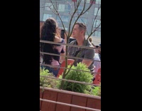 Man wears sunglasses while woman films her