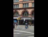 Guy with basketball rides bicycle by starbucks 