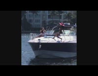 Pink floppy hat girl sits railing boat