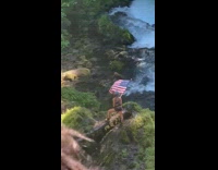 Girl hold american flag stand beside river