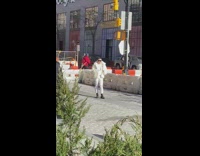 White jacket guy catwalks down sidewalk 