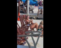 Woman sit chair hold bottle selfie beach