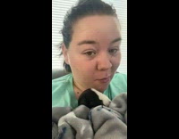 Puppy in cage screams at woman cuddling other dog 