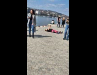 Woman lie down takes picture beside river