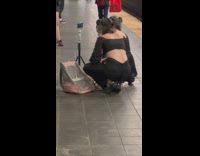 Two women wears a Dinosaur head mask on the subway