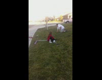 Father and daughter ride scooters and falls off on purpose onto grass lawn