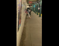 Woman pants down pee beside wall subway