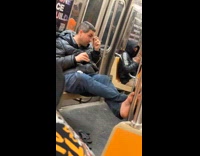 Man puts barefoot at pole inside train