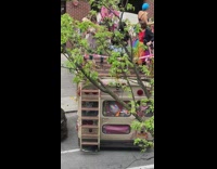 People in colorful outfits dancing atop parked party bus
