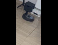 Small puppy climb on robot vacuum cleaner