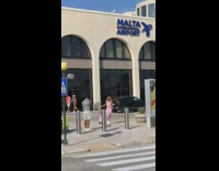 Woman purple leggings baggage outside airport poles