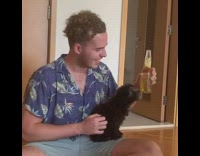 Blue shirt guy beer bottle black dog