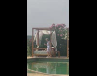 Woman elderly lie down poolside bed photoshoot