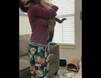 Lady lifts cat helps it stretch 