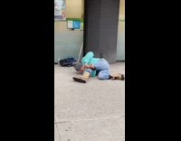 Man beanie turquoise sweater laying on floor sideways playing flute 