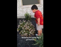Boy waters the plants from his mouth