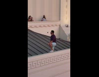 Guy has knee up on ledge at observatory 