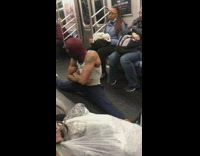 Guy in spiderman mask doing acrobatic moves on subway
