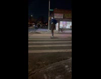 Man cross street carry large sack on head