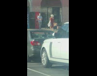 Woman in a red dress poses at the parking lot
