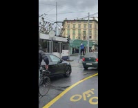 Man standing on a grocery cart train drive by