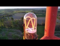 Guy compare hand with large neon lamp 