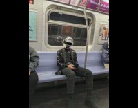 Man with daft punk helmet head on train