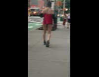 Guy walks on sidewalk with red thong and red silk strap top