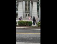 Woman spins around and models for camera in front of random building