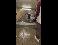 Guy wades through flooded subway station 