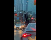 Collab WINY - Man stands on a bike while balancing a tire on his head