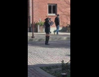 Woman black dress hat shiny sleeves street