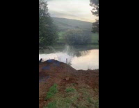 Guy rides jumps blue bicycle into lake 
