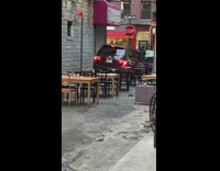 Minivan drives through street closed for outdoor dining