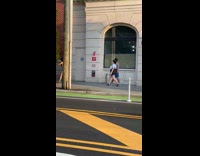 Purple bikini girl records herself walk sidewalk 