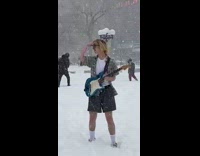 Guy outside in snowstorm with blue guitar 
