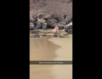 Woman in red bikini with a Santa Hat at the beach