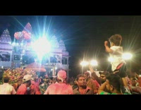 Parent holds baby up over concert festival crowd