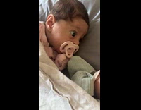 Baby with shocked look seeing twin