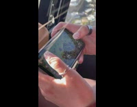 Two people playing clash of clans inside helicopter ride