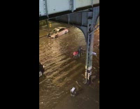 Motorcycle delivery driver in flood waters street