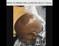 Barber sprays alcohol on bald guys head and beard at barber shop