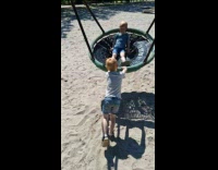 Kid pushes swing then hits himself back