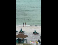 Couple jump shot beach chair blue umbrella