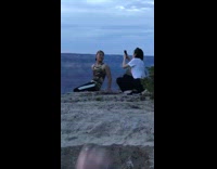 Sunset guy camo shirt girl taking photo edge of rocks