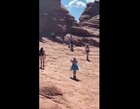 Woman blue dress raise arms pose at the arches park